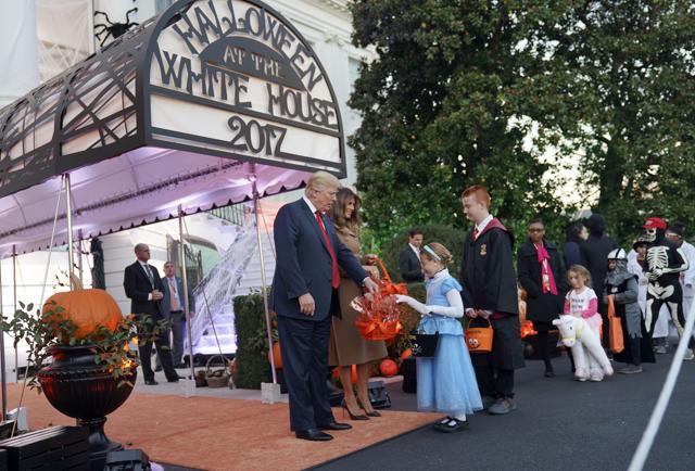 President Donald Trump and first lady Melania Trump hand out treats as they welcome children at the White House. (AP) President Donald Trump and first lady Melania Trump hand out treats as they welcome children at the White House. (AP)
