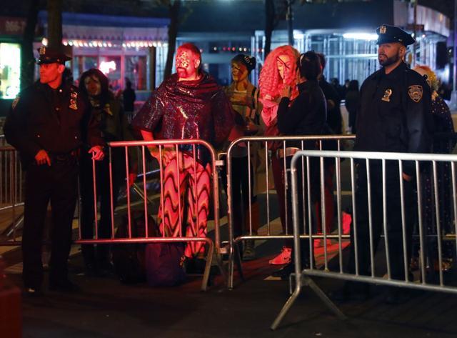 People in costume wait at a barricade with police officers for the New York City Halloween parade. (REUTERS) People in costume wait at a barricade with police officers for the New York City Halloween parade. (REUTERS)