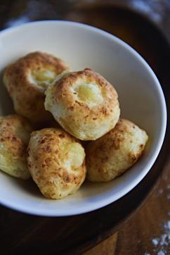 Pao de queijo (pronounced pau-juh-keju) are bonbon-sized pale golden puffs with chewy insides— a perfect combination of carbs and aged dairy. Pao de queijo (pronounced pau-juh-keju) are bonbon-sized pale golden puffs with chewy insides— a perfect combination of carbs and aged dairy.