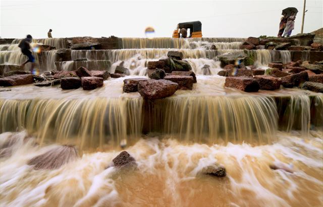 Water flows over a collapsed compound wall in neighbouring Redhills following heavy rainfall in Chennai on Thursday. (PTI Photo) Water flows over a collapsed compound wall in neighbouring Redhills following heavy rainfall in Chennai on Thursday. (PTI Photo)