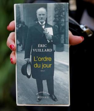 A woman displays French writer Eric Vuillard’s book which won the French literary prize Goncourt in Paris. (AP/Michel Euler)