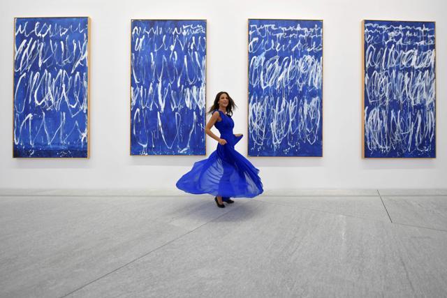A woman poses in front of part of a series of nine panels titled "Untitled I-IX" by American painter Cy Twembly at the Louvre Abu Dhabi Museum. (AFP) A woman poses in front of part of a series of nine panels titled "Untitled I-IX" by American painter Cy Twembly at the Louvre Abu Dhabi Museum. (AFP)
