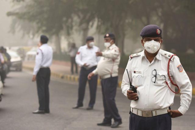 Traffic police cops wear masks as they manage traffic amid heavy haze at Ashoka Road in New Delhi. (Burhaan Kinu / HT Photo) Traffic police cops wear masks as they manage traffic amid heavy haze at Ashoka Road in New Delhi. (Burhaan Kinu / HT Photo)