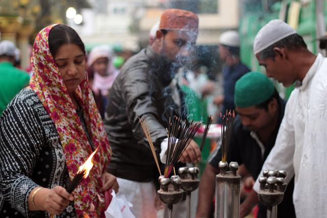 Devotees light incense sticks at the dargah. (Shivam Saxena/Hindustan Times) Devotees light incense sticks at the dargah. (Shivam Saxena/Hindustan Times)