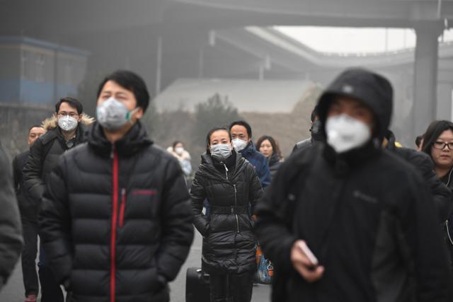 This December 20, 2016 photo shows commuters wearing masks on a polluted day in Beijing. (AFP File Photo)