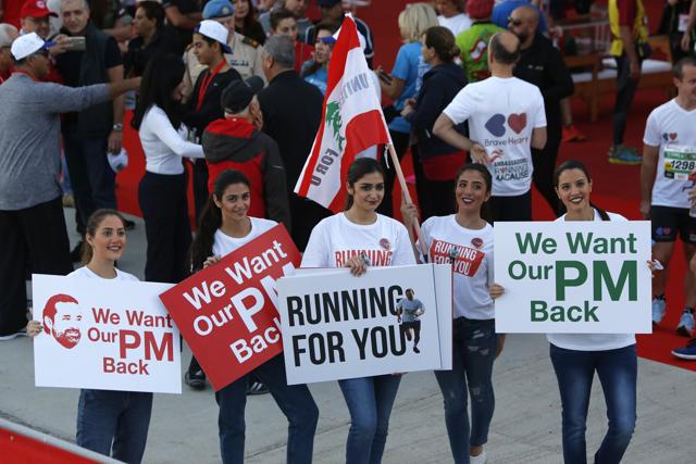 Lebanese women hold placards supporting former Lebanese Prime Minister Saad al-Hariri during the Beirut Marathon on November 12, 2017. (AP)