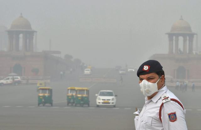 A traffic policeman, wearing an anti-pollution mask, mans traffic amid smog and air pollution which continues to be above dangerous level, at Vijay Chowk in New Delhi. (PTI) A traffic policeman, wearing an anti-pollution mask, mans traffic amid smog and air pollution which continues to be above dangerous level, at Vijay Chowk in New Delhi. (PTI)