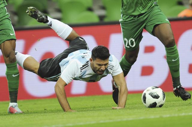 Argentina's Sergio Aguero, center, falls down as he challenges for the ball. (AP) Argentina's Sergio Aguero, center, falls down as he challenges for the ball. (AP)