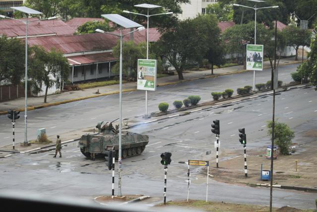 A military tank is seen with armed soldiers on the road leading to President Robert Mugabes office in Harare. (AP Photo)