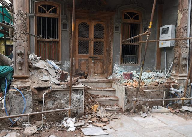 A stray dog sits outside the construction site of an old heritage building being renovated in Ahmedabad. (AFP Photo) A stray dog sits outside the construction site of an old heritage building being renovated in Ahmedabad. (AFP Photo)