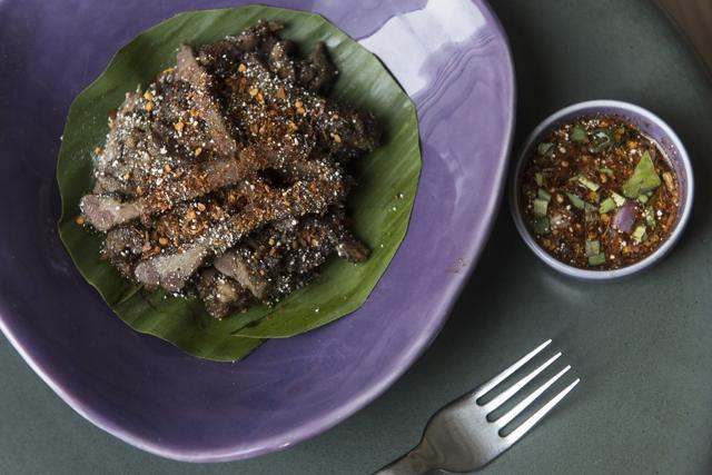 Tossed in a sweet and spicy sauce, the grilled pork with nam jim jeaw sauce is tender and juicy. (Aalok Soni / HT Photo)