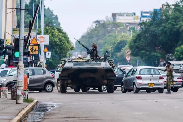 An armoured personnel carrier stations by an intersection as Zimbabwean soldiers regulate traffic in Harare on November 15, 2017. (AFP Photo) An armoured personnel carrier stations by an intersection as Zimbabwean soldiers regulate traffic in Harare on November 15, 2017. (AFP Photo)