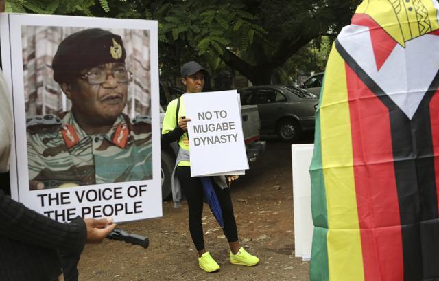 People hold their messages in Harare to demonstrate for the ouster of President Robert Mugabe who is virtually powerless and deserted by most of his allies. (AP Photo) People hold their messages in Harare to demonstrate for the ouster of President Robert Mugabe who is virtually powerless and deserted by most of his allies. (AP Photo)