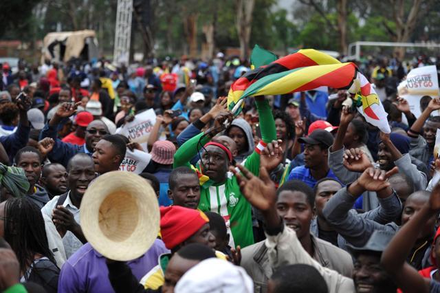 People wave flags and shout slogans during a demonstration demanding the resignation of Zimbabwe's president. (AFP Photo) People wave flags and shout slogans during a demonstration demanding the resignation of Zimbabwe's president. (AFP Photo)