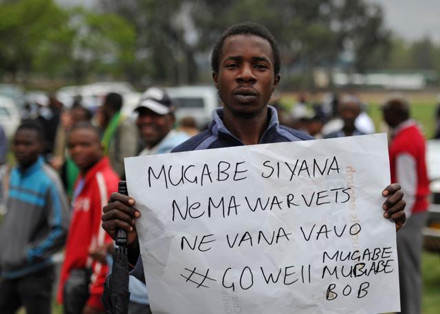A man poses with a sign reading "Mugabe, you have to deal with war vets and their children" during a demonstration demanding the resignation of Zimbabwe's president. (AFP Photo) A man poses with a sign reading "Mugabe, you have to deal with war vets and their children" during a demonstration demanding the resignation of Zimbabwe's president. (AFP Photo)