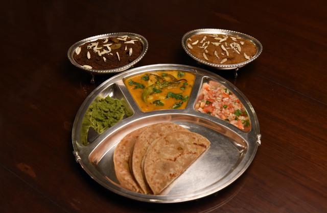 This thal has Channe ki daal ki puri with dapki k aloo with kichumbar salad and amla ki chutney. Served with Sooja and Besan ka halwa. (Photo: Amal KS/HT) This thal has Channe ki daal ki puri with dapki k aloo with kichumbar salad and amla ki chutney. Served with Sooja and Besan ka halwa. (Photo: Amal KS/HT)