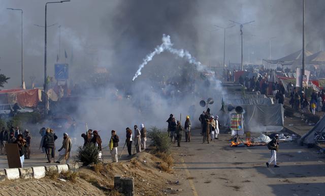 Protesters hurls back a tear gas shell fired by police during a clash in Islamabad, Pakistan, on Saturday. (AP Photo) Protesters hurls back a tear gas shell fired by police during a clash in Islamabad, Pakistan, on Saturday. (AP Photo)