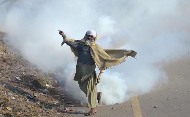 A Pakistani protester of the Tehreek-i-Labaik Yah Rasool Allah Pakistan (TLYRAP) religious group throws a tear gas shell back towards police. (AFP Photo) A Pakistani protester of the Tehreek-i-Labaik Yah Rasool Allah Pakistan (TLYRAP) religious group throws a tear gas shell back towards police. (AFP Photo)