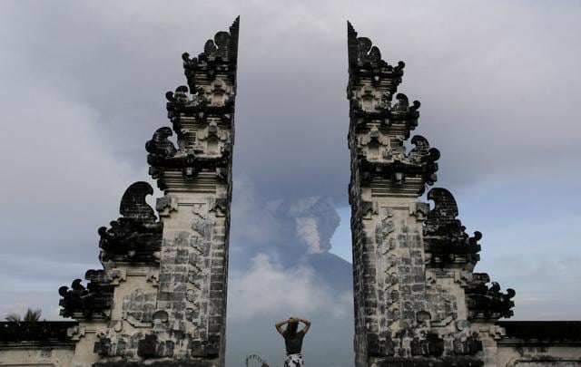 A tourist watches as Mount Agung volcano erupts at Lempuyang Temple in Karangasem, Bali, Indonesia November 27. (Reuters Photo)