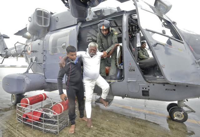 An Indian fisherman who was stranded in the Arabian Sea is escorted down from an Indian Navy helicopter after being rescued in Thiruvananthapuram on Friday. (AP Photo) An Indian fisherman who was stranded in the Arabian Sea is escorted down from an Indian Navy helicopter after being rescued in Thiruvananthapuram on Friday. (AP Photo)