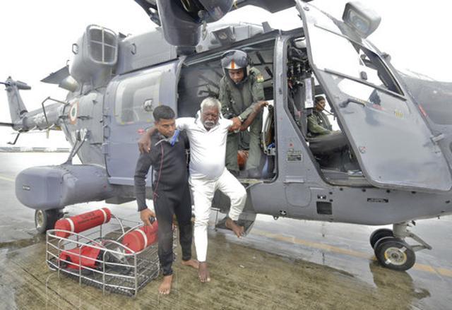 A fisherman who was stranded in the Arabian Sea is escorted down from an Indian Navy helicopter after being rescued in Thiruvananthapuram, Kerala, on Friday. (AP) A fisherman who was stranded in the Arabian Sea is escorted down from an Indian Navy helicopter after being rescued in Thiruvananthapuram, Kerala, on Friday. (AP)