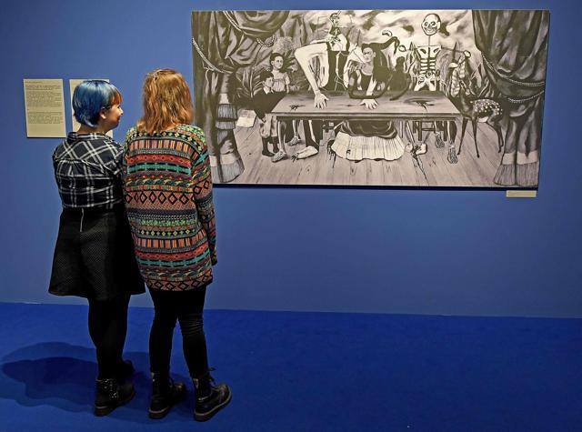 Visitors look at a black-and-white reproduction of a painting titled "The Wounded Table" by late Mexican artist Frida Kahlo. (AFP)
