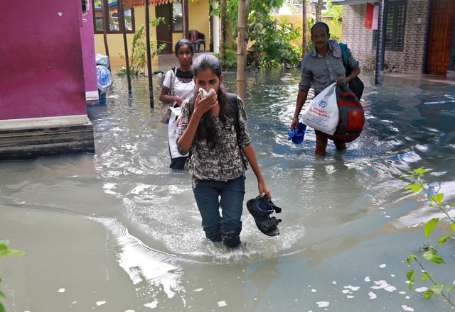 Residents carry their belongings as they evacuate their house after flooding caused by Cyclone Ockhi in the coastal village of Chellanam in Kerala. (REUTERS) Residents carry their belongings as they evacuate their house after flooding caused by Cyclone Ockhi in the coastal village of Chellanam in Kerala. (REUTERS)