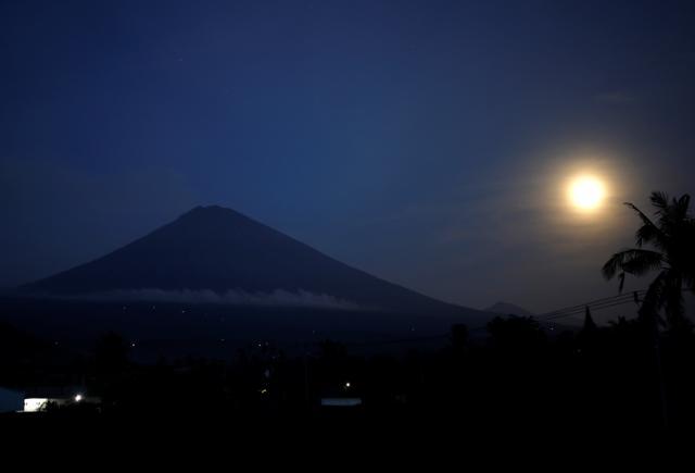 The full-moon is seen along with Mount Agung volcano in Bali on Monday. (Reuters Photo) The full-moon is seen along with Mount Agung volcano in Bali on Monday. (Reuters Photo)