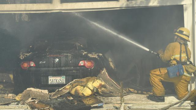 Firefighters battle to save one of many homes burning in an early-morning Creek Fire. (Reuters)