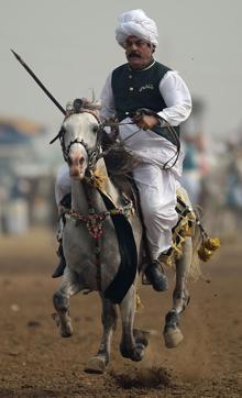 A rider charging across a course holding a lance to pick up pegs at a tent-pegging competition during an annual festival at Kot Fateh Khan in Attock district of Pak Punjab. (AAMIR QURESHI/AFP) A rider charging across a course holding a lance to pick up pegs at a tent-pegging competition during an annual festival at Kot Fateh Khan in Attock district of Pak Punjab. (AAMIR QURESHI/AFP)