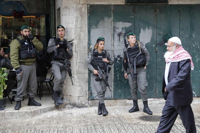 A Palestinian man walks past Israeli border guards standing in Jerusalem's old city just after Damascus' Gate on December 6, 2017. (AFP Photo)