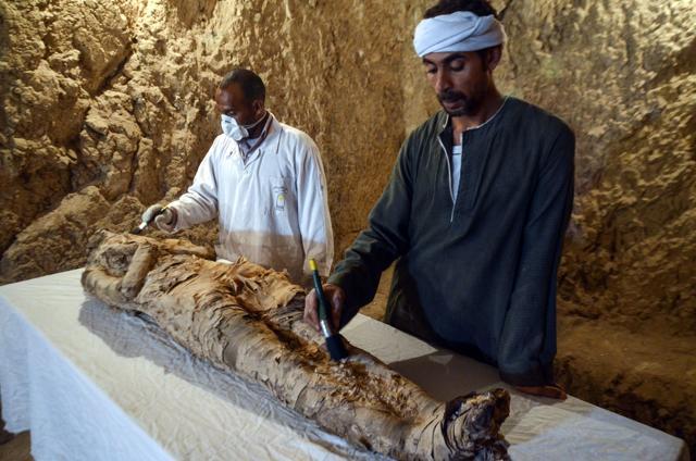 Egyptian archaeological technicians restore a mummy wrapped in linen, found at the newly discovered "Kampp 150" tomb at Draa Abul Naga necropolis on the west Nile bank of the southern Egyptian city of Luxor, about 650 kilometres (400 miles) south of the capital Cairo, on December 9, 2017. (AFP) Egyptian archaeological technicians restore a mummy wrapped in linen, found at the newly discovered "Kampp 150" tomb at Draa Abul Naga necropolis on the west Nile bank of the southern Egyptian city of Luxor, about 650 kilometres (400 miles) south of the capital Cairo, on December 9, 2017. (AFP)