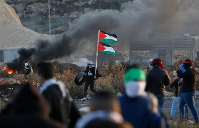 Palestinian protesters clash with Israeli forces near an Israeli checkpoint in the West Bank city of Ramallah on December 9, 2017. (AFP) Palestinian protesters clash with Israeli forces near an Israeli checkpoint in the West Bank city of Ramallah on December 9, 2017. (AFP)