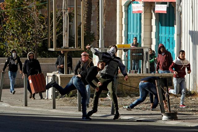 Palestinian protestors throw stones towards Israeli forces during clashes near an Israeli checkpoint in the West Bank town of Bethlehem on December 9, following the US president's decision to recognize the city of Jerusalem as the capital of Israel. (AFP Photo) Palestinian protestors throw stones towards Israeli forces during clashes near an Israeli checkpoint in the West Bank town of Bethlehem on December 9, following the US president's decision to recognize the city of Jerusalem as the capital of Israel. (AFP Photo)