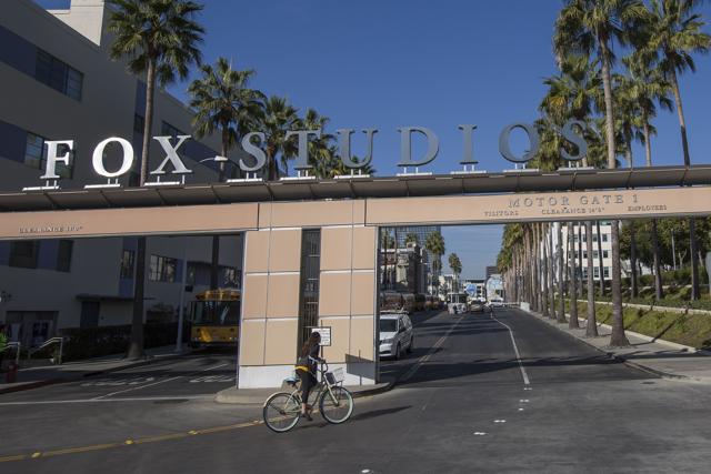 A bicyclist rides through the main entrance to Fox Studios after the Walt Disney Company announced that it will acquire 21st Century Fox on December 14, 2017 in Los Angeles, California. (AFP) A bicyclist rides through the main entrance to Fox Studios after the Walt Disney Company announced that it will acquire 21st Century Fox on December 14, 2017 in Los Angeles, California. (AFP)