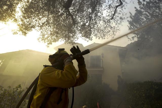 A firefighter from Kern County, Calif., works to put out hot spots during a wildfire Saturday, Dec. 16, 2017, in Montecito, Calif. (AP) A firefighter from Kern County, Calif., works to put out hot spots during a wildfire Saturday, Dec. 16, 2017, in Montecito, Calif. (AP)