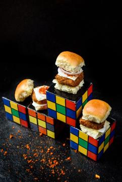 Mini burgers placed on rubix cubes . Mini burgers placed on rubix cubes .