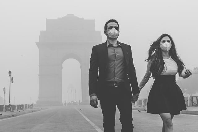 A couple poses for a photo shoot amid thick smog wearing anti-pollution masks at India Gate, Delhi. (Photo: Ashish Pareek) A couple poses for a photo shoot amid thick smog wearing anti-pollution masks at India Gate, Delhi. (Photo: Ashish Pareek)