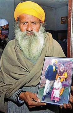 Gurmail’s father showing a family photograph. (Sameer Sehgal/HT)