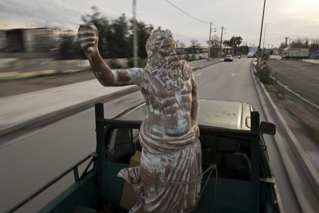 A pickup track drives on a street of Athens carrying a terracotta statue of Zeus, chief among the ancient Greek gods, made by Goumas. (AP) A pickup track drives on a street of Athens carrying a terracotta statue of Zeus, chief among the ancient Greek gods, made by Goumas. (AP)