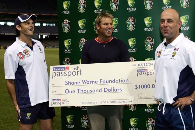 Adam Gilchrist and Darren Lehmann of Australia present a cheque to Shane Warne for his charity on behalf of Travelex after Lehmann's sprint race after training at Telstra Dome on December 4, 2004 in Melbourne. (Getty Images)
