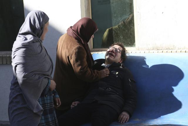 Two women console a man outside a hospital following a suicide attack in Kabul, Afghanistan. (AP Photo) Two women console a man outside a hospital following a suicide attack in Kabul, Afghanistan. (AP Photo)