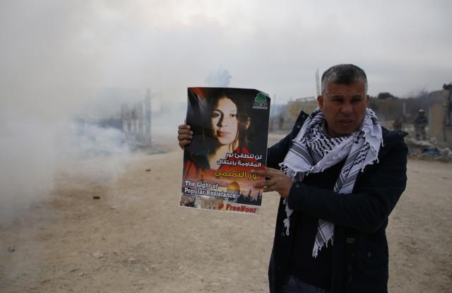 A Palestinian protester holds a poster calling for the release of Nour Naji Tamimi, cousin of a prominent Palestinian campaigner held by Israel, outside Israel's Offer prison in the West Bank village of Betunia (AFP) A Palestinian protester holds a poster calling for the release of Nour Naji Tamimi, cousin of a prominent Palestinian campaigner held by Israel, outside Israel's Offer prison in the West Bank village of Betunia (AFP)