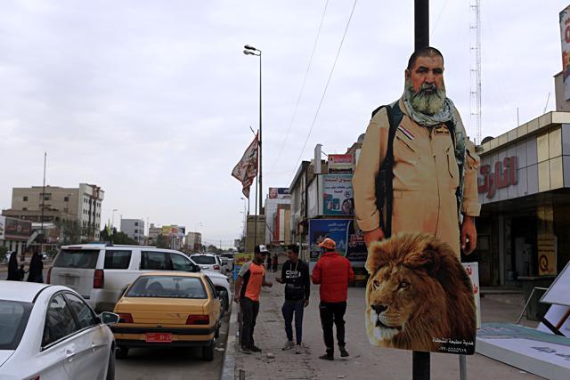 In this November 26, 2017 photo, people pass by a poster of Ali Jayad al-Salhi. (AP) In this November 26, 2017 photo, people pass by a poster of Ali Jayad al-Salhi. (AP)