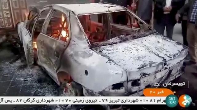 People stand near a burning car in Tuyserkan, Hamadan Province, Iran, December 31, 2017 in this still image taken from video. (IRINN/ ReutersTV via Reuters) People stand near a burning car in Tuyserkan, Hamadan Province, Iran, December 31, 2017 in this still image taken from video. (IRINN/ ReutersTV via Reuters)
