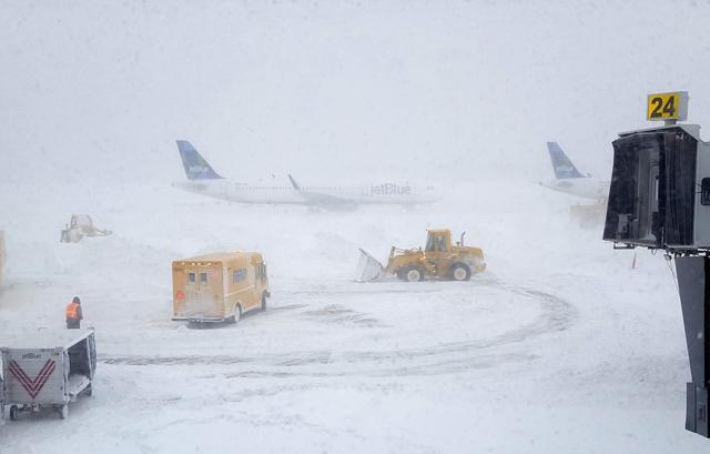 Snow plows move snow as a JetBlue airplane waits outside terminal five at John F Kennedy International Airport in the Queens borough of New York City. (AFP) Snow plows move snow as a JetBlue airplane waits outside terminal five at John F Kennedy International Airport in the Queens borough of New York City. (AFP)