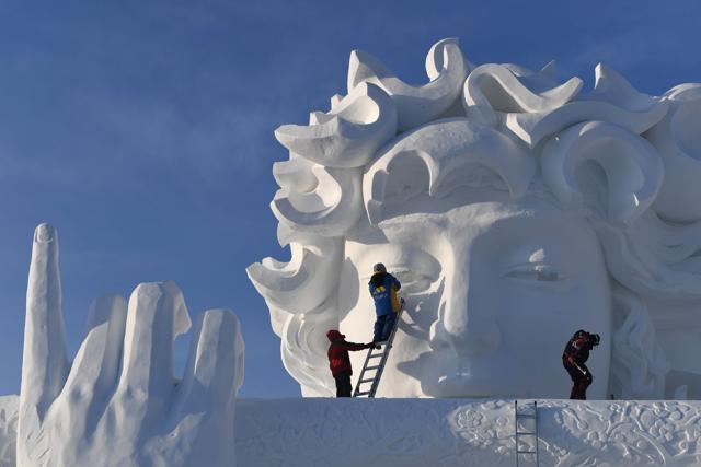 Workers carve a snow sculpture before the opening of the festival. (AFP) Workers carve a snow sculpture before the opening of the festival. (AFP)