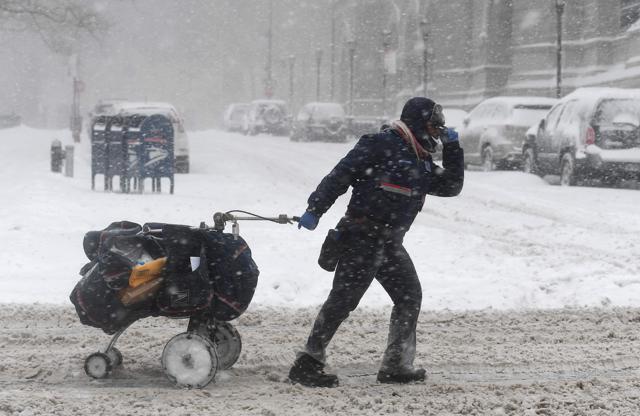 A mail delivery person pulls her cart through the snow on January 4, 2018 in Brooklyn, New York. (AFP Photo)