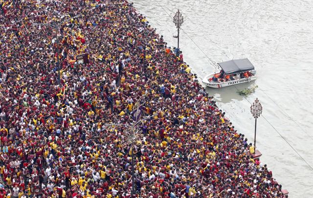 A Philippine Coast Guard rescue boat is on standby as Filipino Roman Catholic devotees jam the Jones Bridge during a raucous procession to celebrate the feast day of the Black Nazarene. (AP) A Philippine Coast Guard rescue boat is on standby as Filipino Roman Catholic devotees jam the Jones Bridge during a raucous procession to celebrate the feast day of the Black Nazarene. (AP)