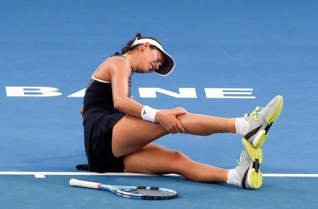 Garbine Muguruza of Spain grabs her leg in pain before retiring from her second round match. (AFP) Garbine Muguruza of Spain grabs her leg in pain before retiring from her second round match. (AFP)